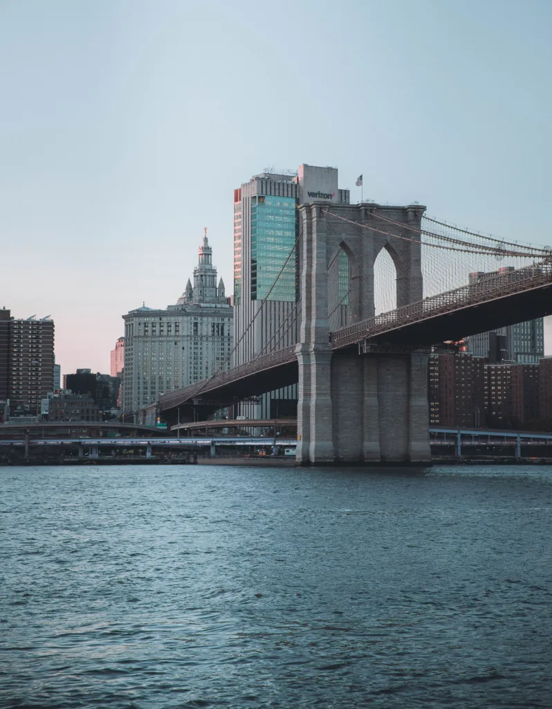 Brooklyn Bridge stretching toward the lower Manhattan skyline at dusk